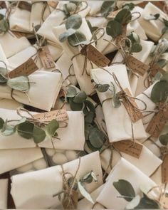 many wrapped gift bags with green leaves and tags tied to each other on twine