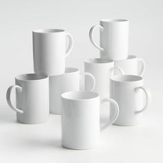 several white coffee mugs stacked on top of each other