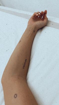 a person laying in bed with their hand on the side of his arm and writing on it