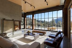 a living room with large windows and leather furniture