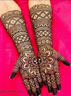 two hands with henna designs on them, one is black and the other is white