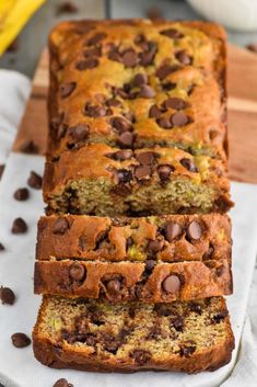 sliced loaf of chocolate chip banana bread on a cutting board with bananas in the background