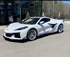 a white sports car parked in front of a building