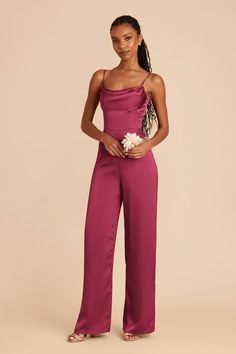 a woman wearing a pink jumpsuit with one shoulder and lace detail on the back