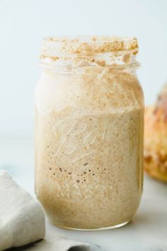 a glass jar filled with food sitting on top of a white counter next to a napkin