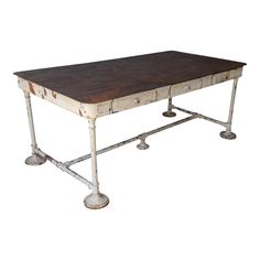 an old wooden table with metal legs