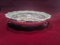 a silver bowl sitting on top of a red table