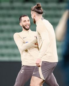 two soccer players are laughing while standing on the field