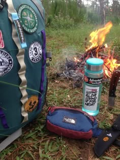 a backpack sitting next to a fire in the woods