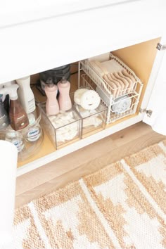 an open cabinet filled with bathroom items on top of a rug