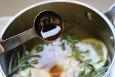 someone is cooking something in a pot on the stove with a ladle full of oil