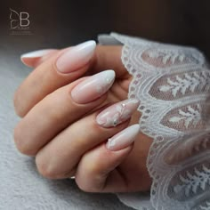 a woman's hand with white and pink manies on it, holding onto her lace