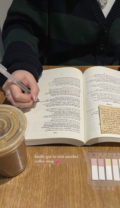 a person sitting at a table with an open book and pen in front of them