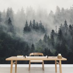 a wooden table sitting in front of a forest wallpapered with fog and trees