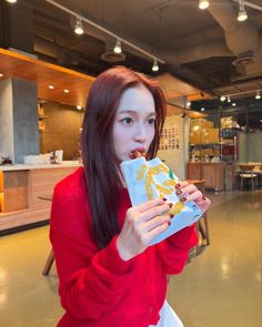 a woman in a red sweater eating food