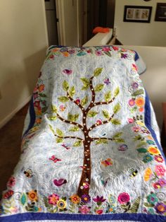 a bed with a tree quilt on top of it