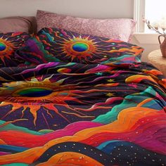 a bed covered in a colorful comforter next to a night sky with sunflowers