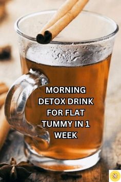 a glass mug filled with tea and cinnamon sticks