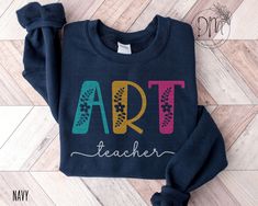 a sweatshirt with the words art teacher on it