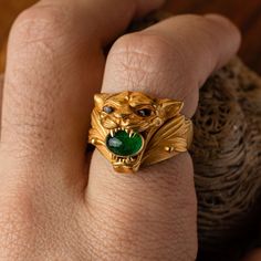 Emanate strength and elegance with this meticulously crafted jaguar ring in 18K gold. The majestic jaguar, symbolizing power and grace, showcases an emerald held firmly in its jaws, bringing a flash of lush brilliance. Further enhancing the design, its piercing eyes are intricately micro-sculpted from citrine, punctuated by black tourmaline pupils, adding depth and intrigue to the gaze. Materials: 18K gold with emerald, citrine, and black tourmaline details Measurements: Approximately 15mm tall Mens Gold Signet Rings, Golden Jaguar, Wearing Rings, Mens Emerald Rings, Mens Diamond Ring, Stone Ring Design, Mens Ring Designs, Man Jewelry, Cat Hug