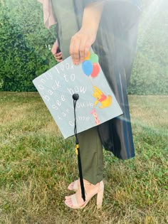 a person standing in the grass holding a sign