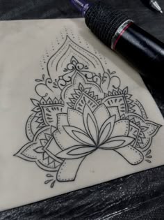 a black pen is sitting on top of a piece of paper with an intricate design