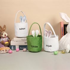 three easter baskets sitting on top of a table next to some books and stuffed animals