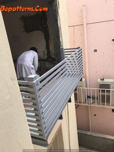 a man standing on top of a balcony next to a metal railing and window sill