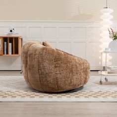 a large bean bag chair sitting on top of a rug in front of a white wall