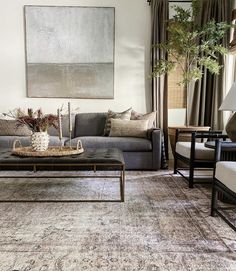 a living room filled with furniture and a painting hanging on the wall over a coffee table