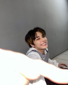 a young man sitting in front of a laptop computer on top of a white floor