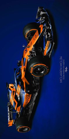 an orange and blue race car is shown in this artistic photo, with the wheels still attached