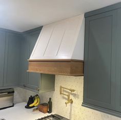 a stove top oven sitting inside of a kitchen next to blue cabinets and counter tops