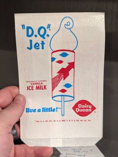 a person holding up a piece of paper with an ice milk advertisement on it