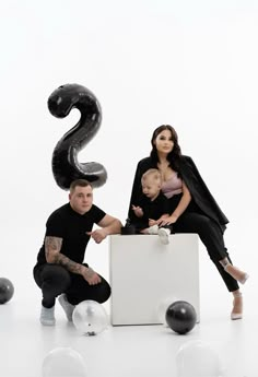 a man, woman and child posing for a photo with balloons in the shape of numbers