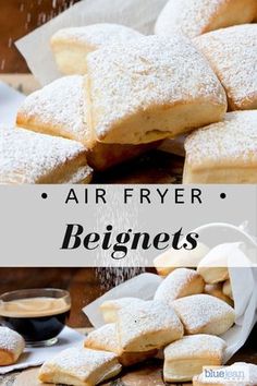 a pile of powdered sugar cookies sitting on top of a wooden table next to a cup of coffee