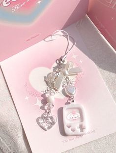 a pink box with some charms on it and a hello kitty keychain hanging from the front