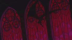 three stained glass windows in the dark