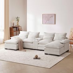 a living room with a large white sectional couch and rug on top of the floor