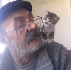 a man with glasses and a cat on his shoulder