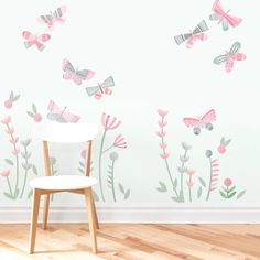 a white table sitting in front of a wall with pink flowers and butterflies on it