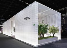 a white booth with plants and trees on display