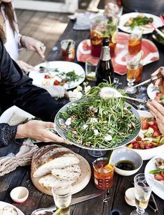 several people sitting at a table with food and drinks