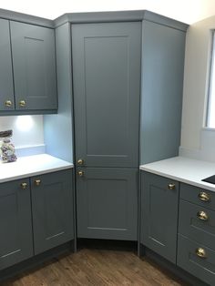 a kitchen with gray cabinets and white counter tops