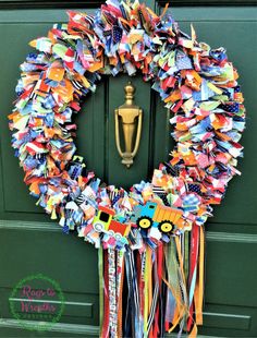 a wreath made out of books is hanging on the front door with ribbons around it