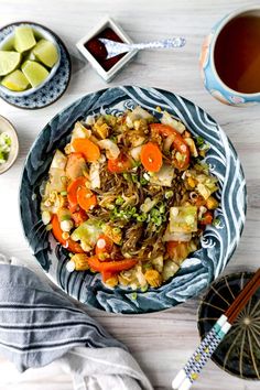 a bowl filled with vegetables next to two cups of tea