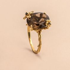 The delicate floral details on this ring surrounds the stunning oval cut smoky quartz to set a statement you didn't know you needed. Approximate stone measurement: 3/8” x 1/2” Finish: 18k gold plated Material: sterling silver, genuine smoky quartz gemstone Item #: 13055 FAIRPRICING $ 115TOORIGINAL | $150 ESTIMATED RETAIL All of our items are priced specially while keeping the same high standard quality. Gold Oval Gemstone Flower Ring, Smokey Quartz Ring Engagement, Gold Oval Flower Ring, Oval Gold Flower Ring With Rose Cut Diamonds, Luxury Gold Oval Flower Ring, Smokey Quartz Ring, Onyx Engagement Ring, Quartz Engagement Ring, Smoky Quartz Ring