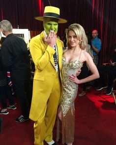 a man in a yellow suit standing next to a woman