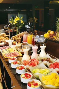 an assortment of fruits and other foods on a buffet table in a hotel or restaurant