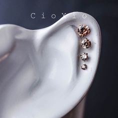 a pair of ear piercings sitting on top of a white object with the word ciovo above it